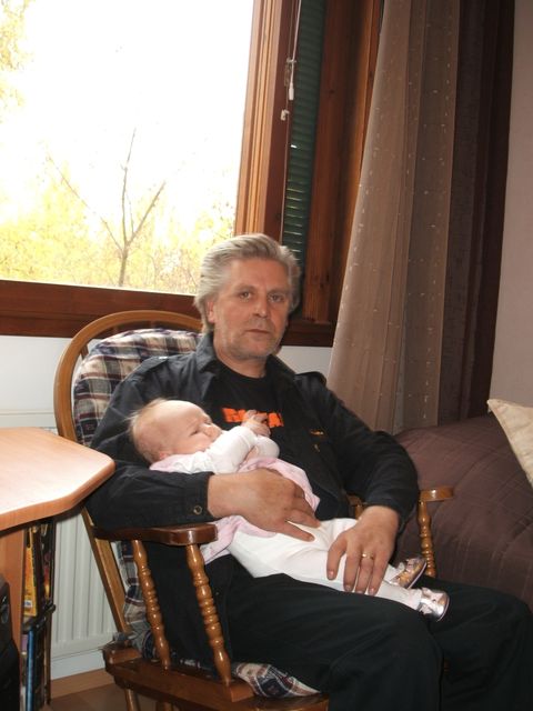 Keinutuolissa vauva sylissä